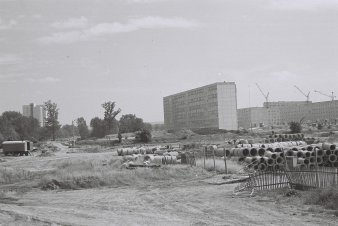 Baulandschaft mit Neubaublock im Hintergrund