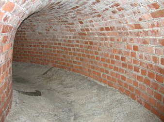 mit Backsteinen gemauerter Tunnelrundbogen und Betonfußboden