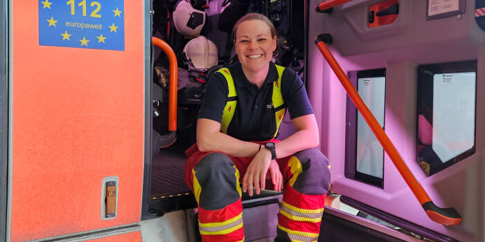 eine Frau in Feuerwehr-Uniform sitzt in einem Löschfahrzeug